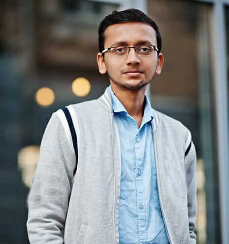 South asian indian male student wear eyeglasses and casual posed outdoor.